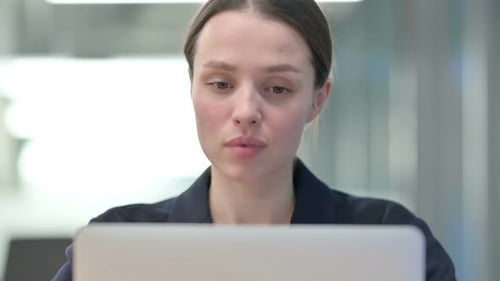 Young Woman Video Calling on Laptop in Office