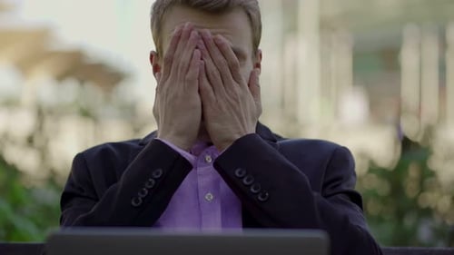 Stressed Man Working Outside on Computer