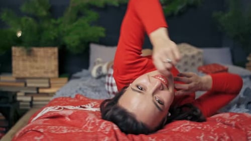 Woman Lying on Decorated Bed at Christmas Time