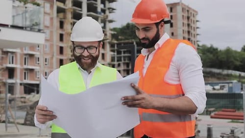 Building a Residential Complex or Business Center. Team of Engineers Men Analyze Plans Construction