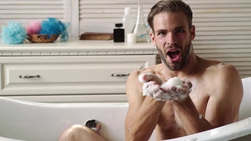 Man Blows Soap Suds from Bathtub
