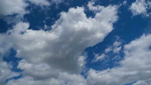 Fluffy White Clouds Moving Across Blue Sky