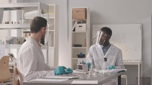 Two Diverse Scientists Working with Substances in Lab
