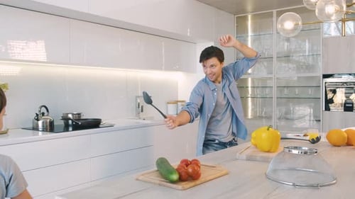 Father and Son Playfully Spar in Bright Kitchen