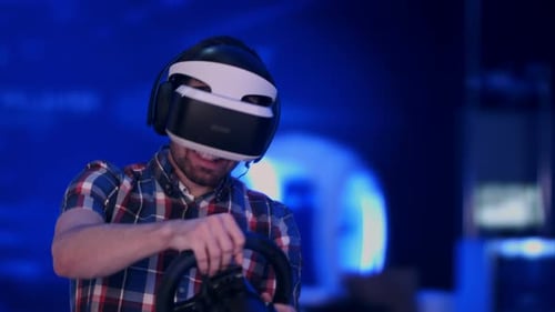 Man Plays Racing Game with VR Headset