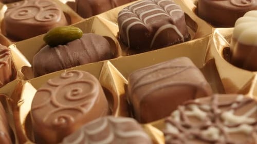 Package box of chocolates many different candies slow tilt 4K 2160p 30fps UltraHD footage - Tilting