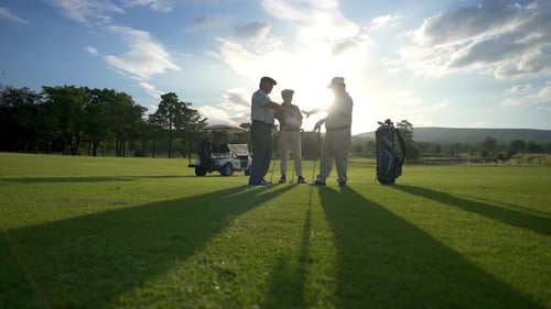 4K Group of Asian men golfer shaking hand after finish the game on golf course at summer sunset