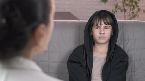 Teen Girl Sits, Frowns, Crosses Arms