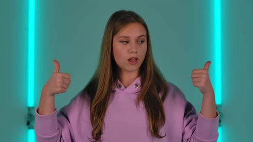 Young Woman Gives Double Thumbs Up With Color Lights