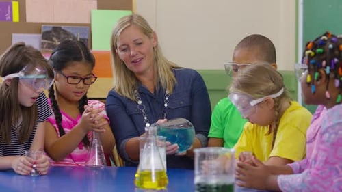 Teacher and students doing science experiment in school classroom