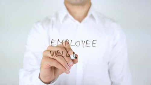 Man Writes Employee Wellness on Transparent Surface