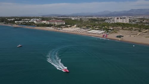 Parasailing Pulled By Speedboat Leaves the Beach