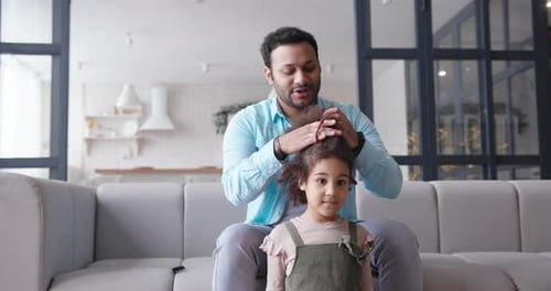 Loving Father Styling Child's Hair at Home