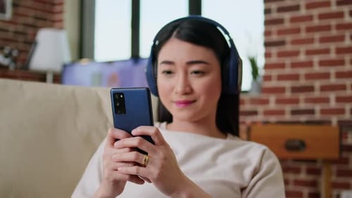 Woman with Headphones Using Phone