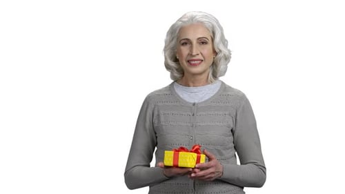 Senior Woman Holds Out Wrapped Birthday Gift