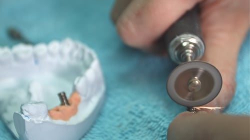 Technician Modifying Dental Implants with Rotary Tool