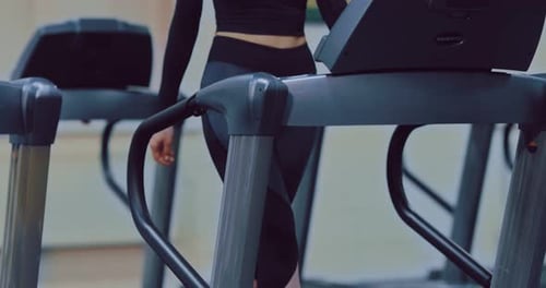 Young Beautiful Woman is Engaged in Fitness in the Gym Running Track