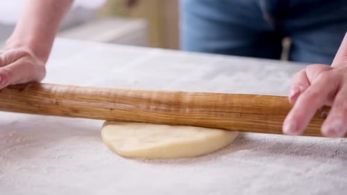 Rolling Dough with a Rolling Pin in Kitchen