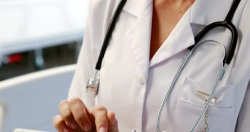 Smiling Doctor Using Tablet in Hospital Close Up