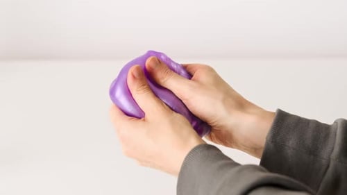 Playing with slime, stretching the gooey substance for fun and stress relief.