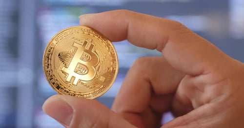 Gold Bitcoin Coin Held in Hand Close Up