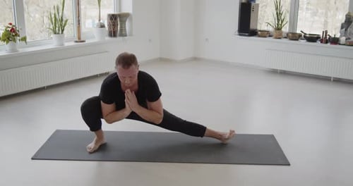 Man Practicing Yoga on Mat Indoors