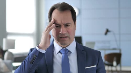 Man Experiencing Headache in Office Environment