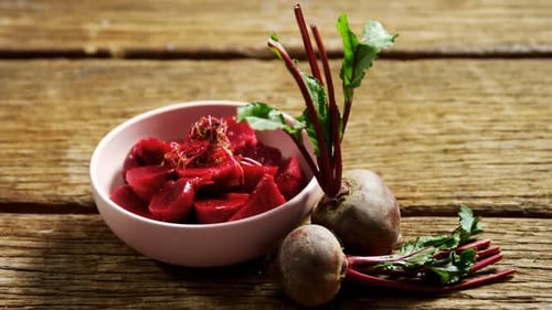 Fresh Beets and Cut Pieces on Rustic Table