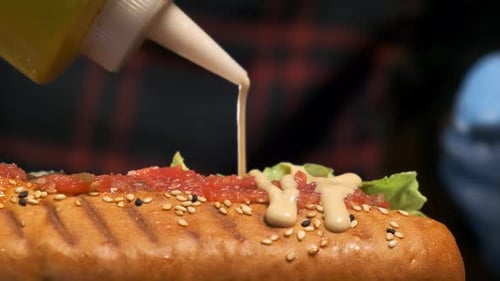 Close Up of Sauce Being Added to Hotdog