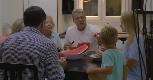 Family Enjoys Watermelon Together Indoors