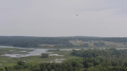Prise de vue par Drone d'un petit avion Cessna survolant le marais de Scarborough dans le Maine.