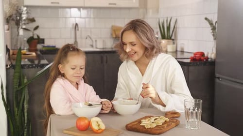 Happy Woman and Girl Enjoying Breakfast Together