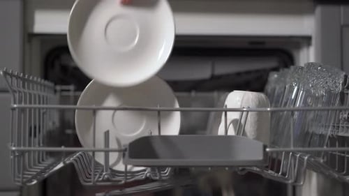 Loading White Dishes into Open Dishwasher