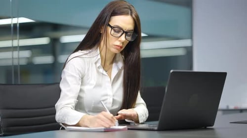Businesswoman Writing Schedule for Meeting in Office