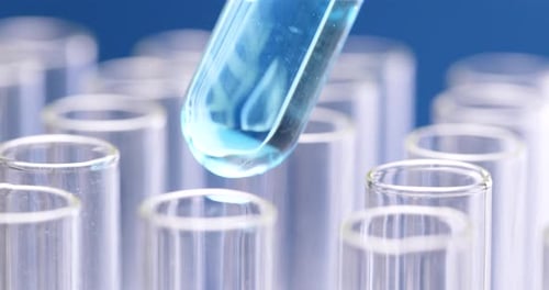 Adding Blue Liquid to Test Tube in Rack