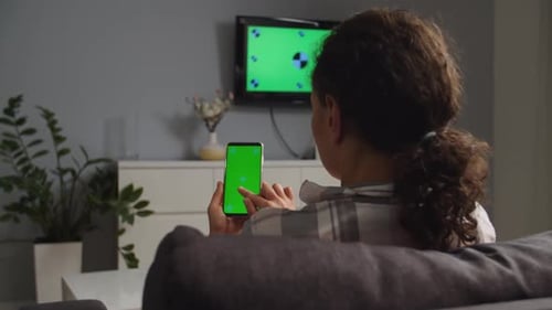 Woman Using Green Screen Smartphone on Couch