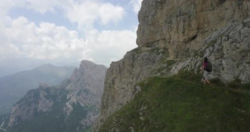 Aerial drone view of a woman hiking in the mountains.