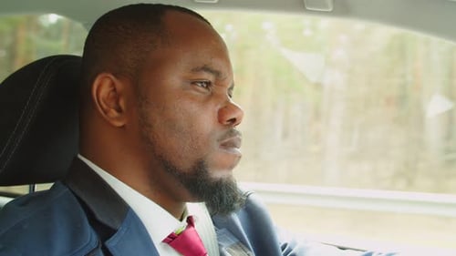 Portrait of Confident African Businessman Driving Car on Motorway
