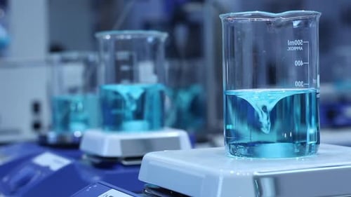 Light Blue Liquid Mixing in Science Laboratory Beaker