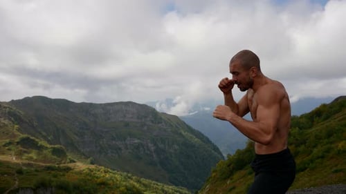 Shirtless Man Boxing Training on Mountain Top