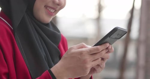 Close up hand Muslim woman chatting on smartphone at outdoor