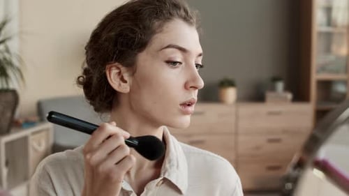 Woman Applies Makeup With Brush at Home