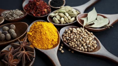 Variety of Colorful Spices in Wooden Spoons