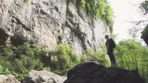 Man Exploring Waterfall Landscape in Wilderness Area