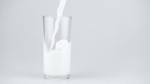 Milk Being Poured Into Clear Glass