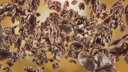 Shelled Walnuts Floating Against Golden Background