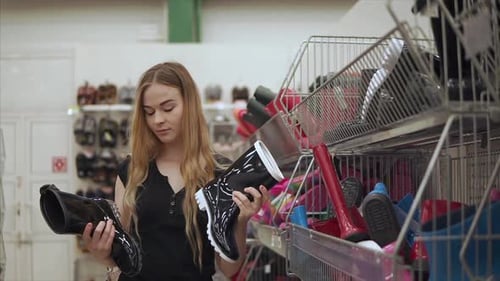 Young Woman Shopping for Rain Boots in Store