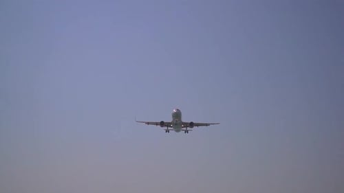 an aircraft is approaching the landing strip and flies over the camera very closely.