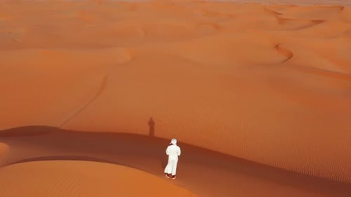 Aerial Of Man Stands On Dune In Desert