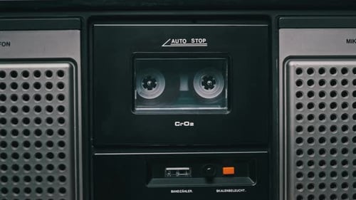 Vintage Transparent Audio Cassette Playing in Deck of an Old Tape Recorder